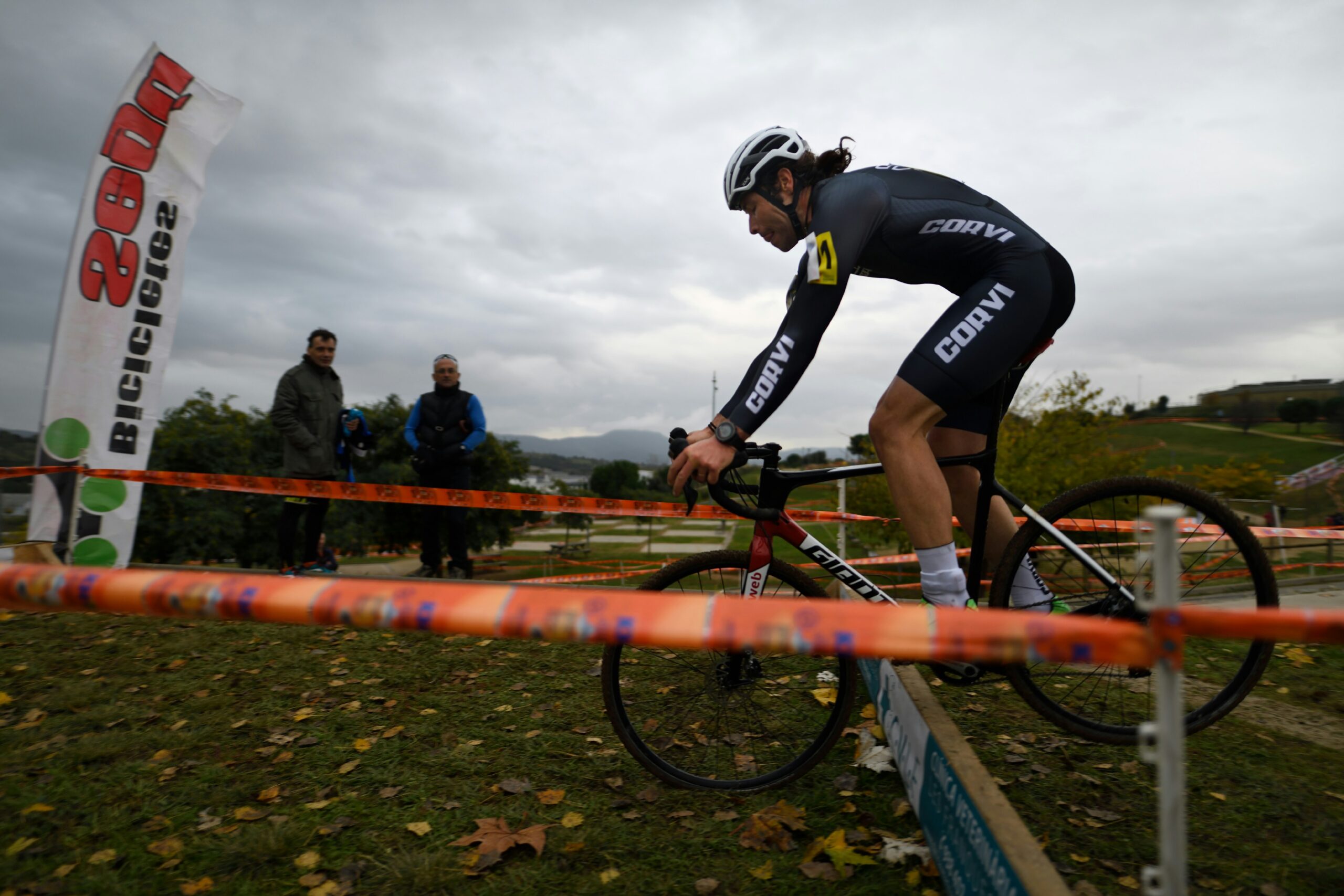 a cyclist jumping a timber in a cyclocross